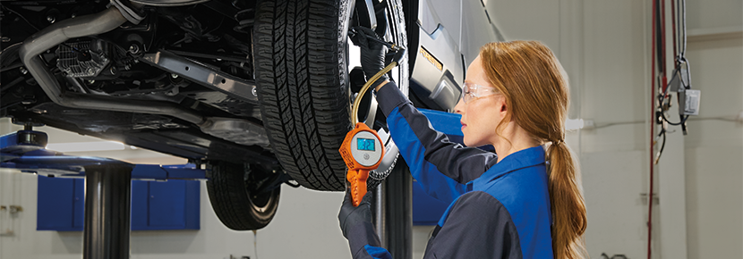 A Subaru technician checking tire pressure. | Subaru of North Miami in Miami FL