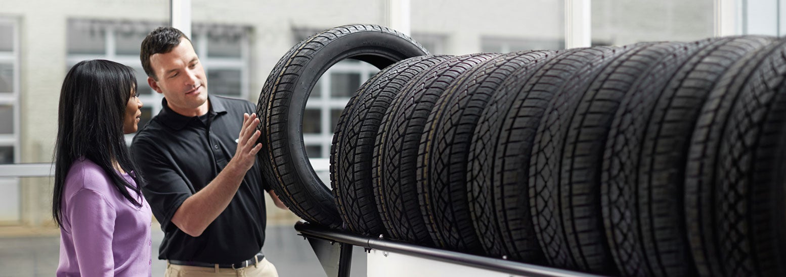 Subaru service representative showing customer a tire. | Subaru of North Miami in Miami FL